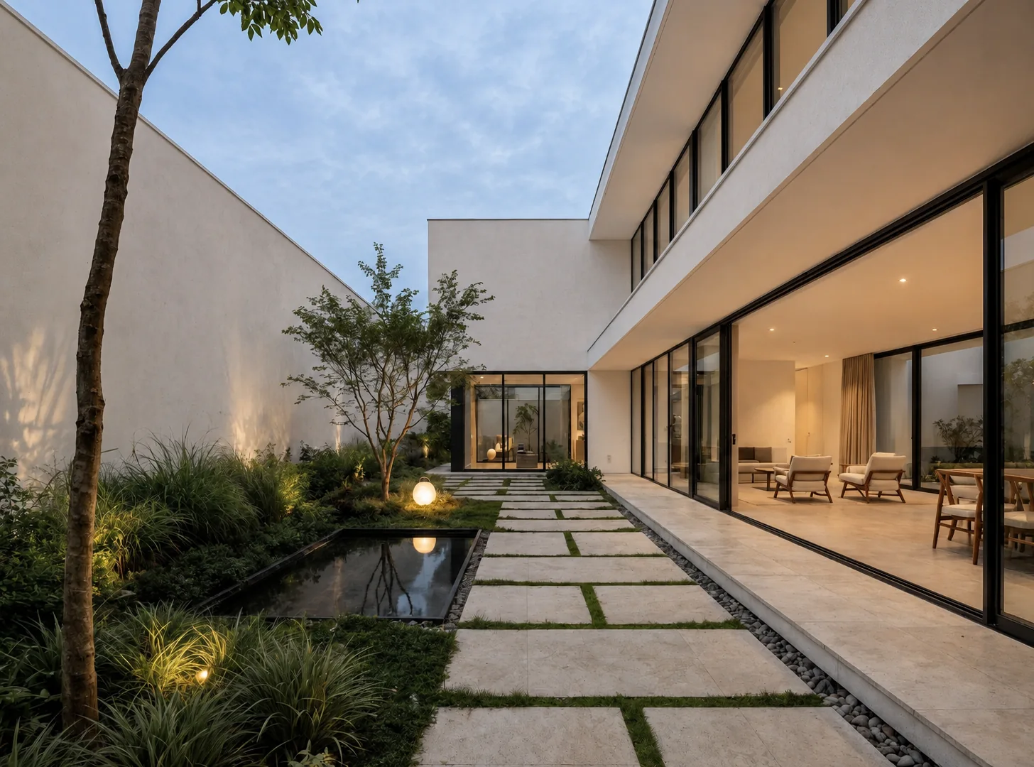 Modern courtyard with floor-to-ceiling black-framed glazing, stone pathway, reflecting pool and garden planting