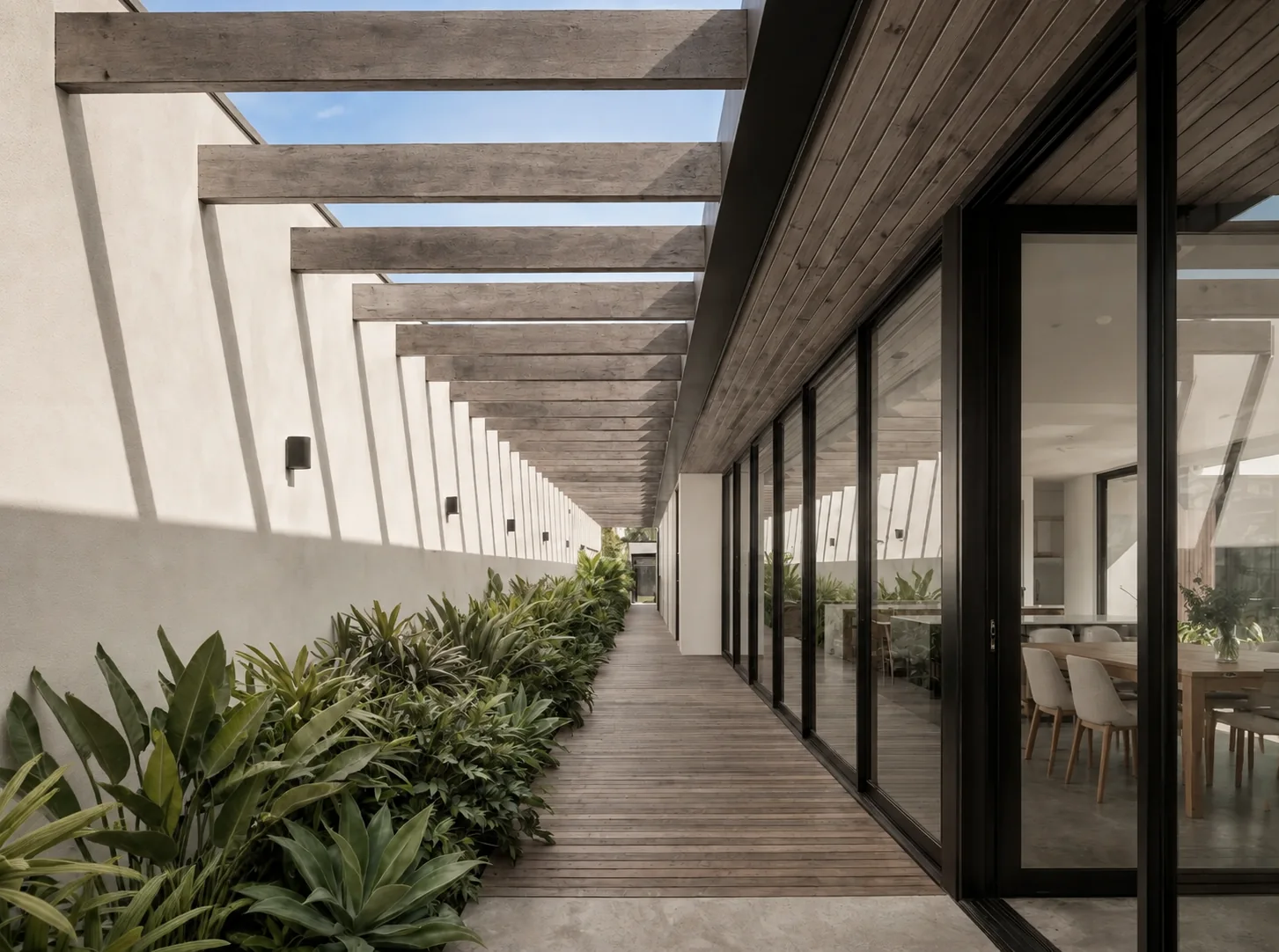 Covered walkway with timber pergola beams and a long black-framed glass facade with sliding doors